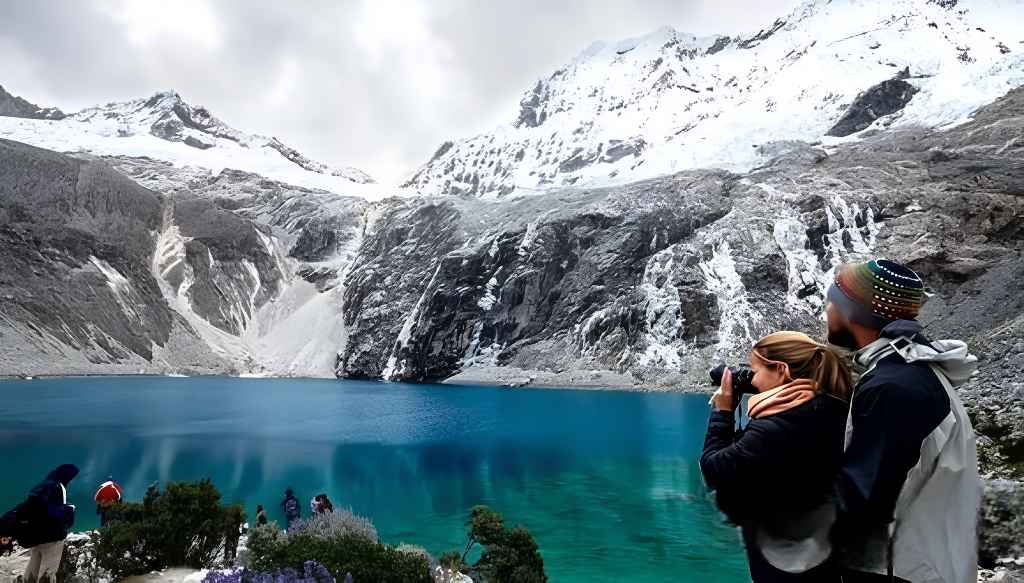 Turistas toman fotografías desde una laguna en el Parque Nacional Huascarán, Áncash