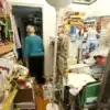 Persona rodeada de objetos acumulados dentro de una vivienda por trastorno de acumulación compulsiva