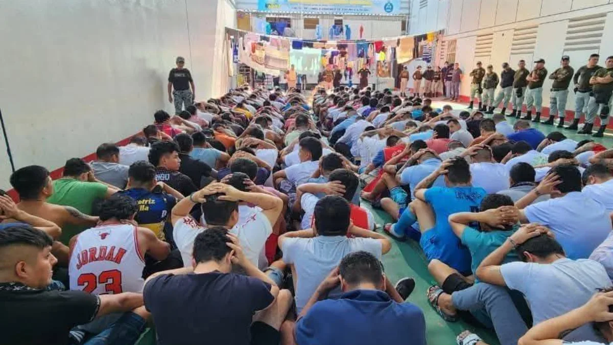 Reclusos sentados con las manos levantadas durante operativo en el penal Cambio Puente de Chimbote bajo supervisión policial