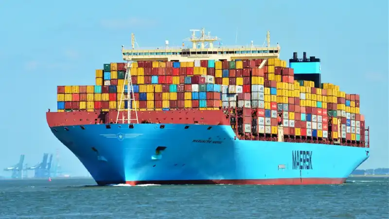 Vista de un gran barco carguero en el mar, transportando contenedores llenos de productos pesqueros peruanos certificados para exportación.