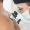 Especialista dermatóloga examina la piel de un paciente para detectar cáncer de piel de forma temprana.