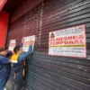 Funcionarios de la MPS colocan el cartel de clausurado en el local de Plaza Vea en Chimbote.