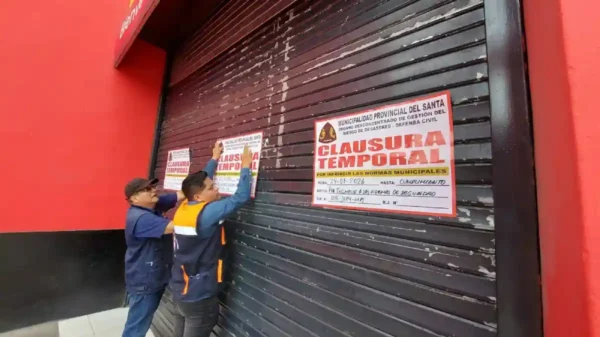 Funcionarios de la MPS colocan el cartel de clausurado en el local de Plaza Vea en Chimbote.