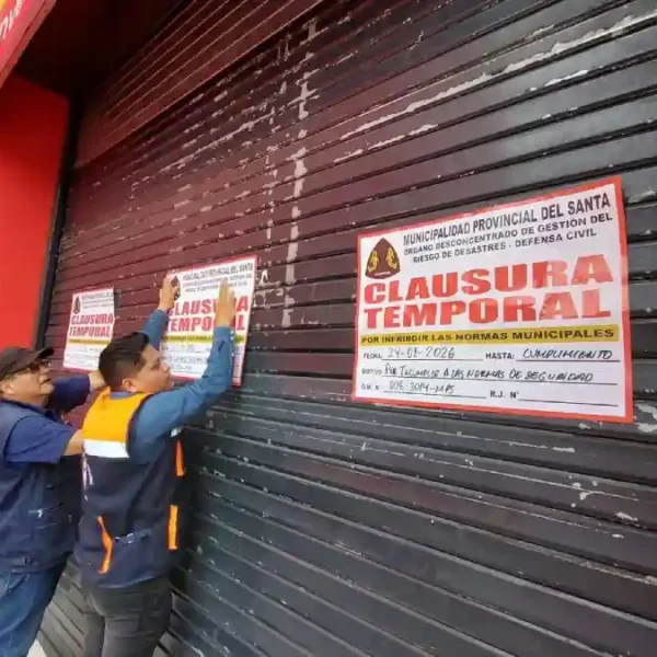 Funcionarios de la MPS colocan el cartel de clausurado en el local de Plaza Vea en Chimbote.