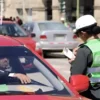 Policía de tránsito imponiendo una infracción a un conductor en Perú, beneficio de descuento multas de tránsito.