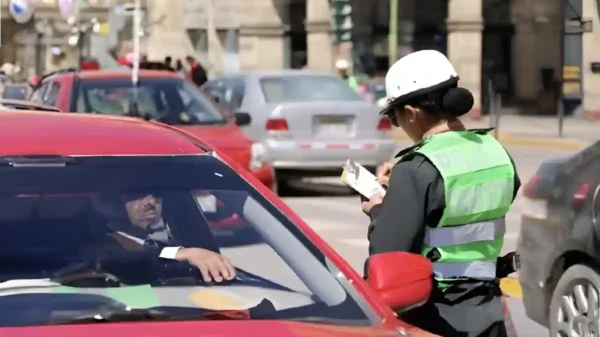 Policía de tránsito imponiendo una infracción a un conductor en Perú, beneficio de descuento multas de tránsito.