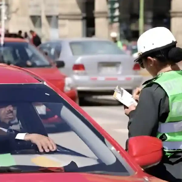 Policía de tránsito imponiendo una infracción a un conductor en Perú, beneficio de descuento multas de tránsito.