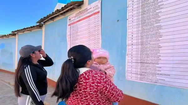 Ciudadanos revisan las listas y mesas de sufragio en Pallasca pegadas en la pared