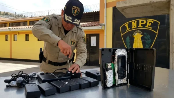 Agente del INPE desarmando una radio que escondía celulares ocultos en el penal Huaraz para evitar extorsiones.