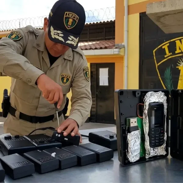 Agente del INPE desarmando una radio que escondía celulares ocultos en el penal Huaraz para evitar extorsiones.
